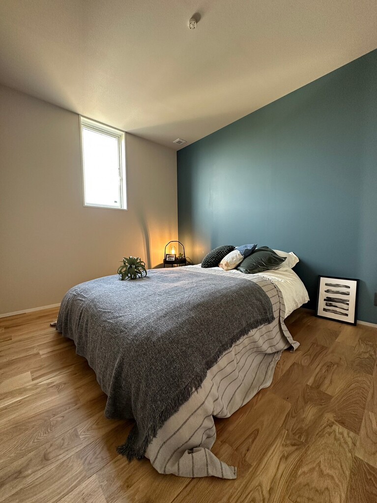 木目の床に、ブルーグレーの壁面がスタイリッシュな寝室