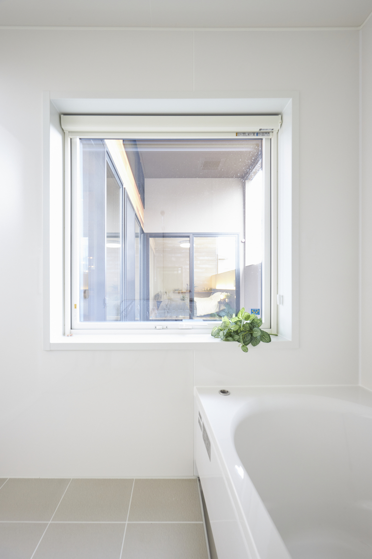 白で統一された浴室。バスタブでゆったり足を伸ばして、大きめの窓で解放感に浸れる